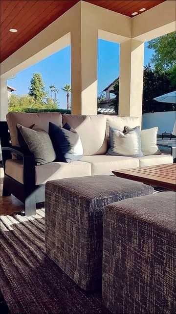 Covered patio with deep seating and woven ottomans