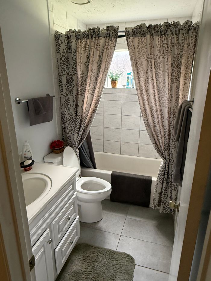 Before: hall bath with dated tile and fixtures