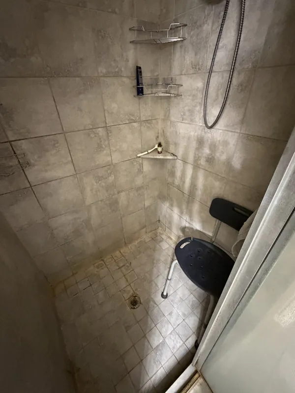 Before purchase: an old shower with worn tile and fittings